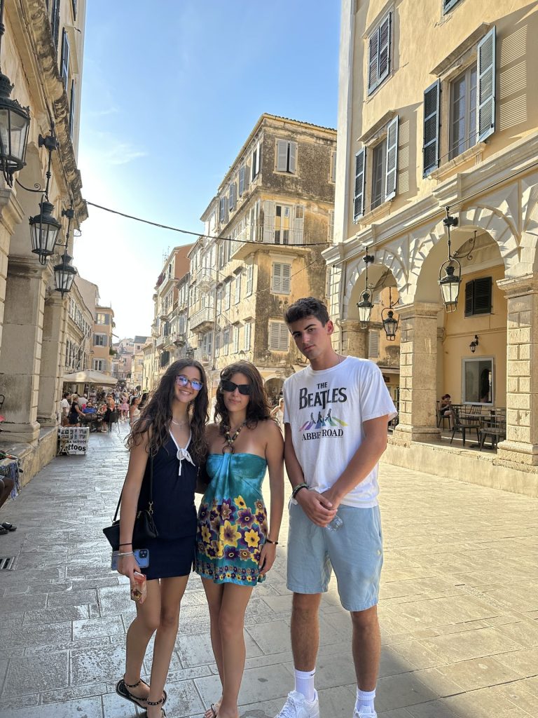 this is a photo of me, my friend, and her brother on the streets of corfu
